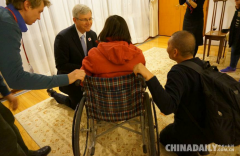 加拿大驻华大使半跪在地与女士交流